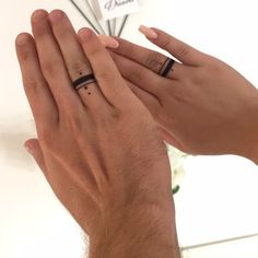 two people holding each other's hands with their wedding rings on top of them