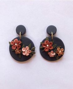 the earrings are decorated with flowers and leaves