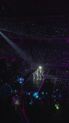 a group of people standing on top of a stage in front of an audience at a concert