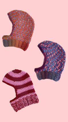 three knitted hats on a pink background