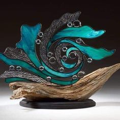 a piece of art that is on top of a tree branch and has been made to look like an ocean wave