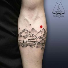 a man with a tattoo on his arm that has mountains and a red dot in the middle