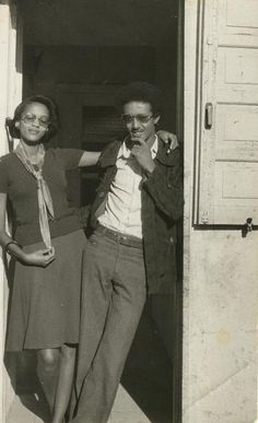 an old black and white photo of two people standing in front of a door with the words classic american love on it