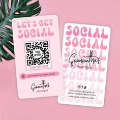 two pink social cards sitting on top of a pink table next to a green leaf