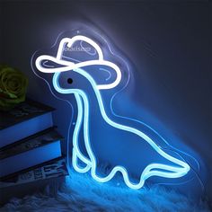 a neon sign with a dog wearing a hat on it's head, sitting next to a stack of books