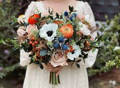 a woman holding a bouquet of flowers in her hands