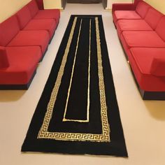 a living room filled with red couches and a black rug