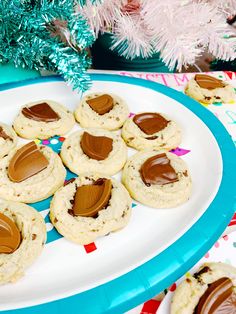 cookies with peanut butter and chocolate are on a plate next to a pink christmas tree