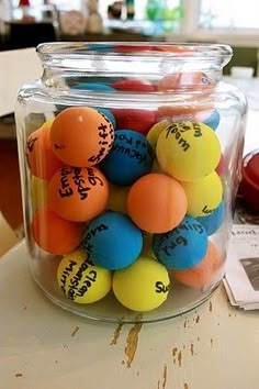 a glass jar filled with lots of colorful balls