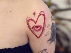 a woman's arm with an eye and heart tattoo on her left upper arm