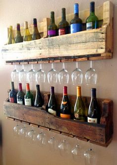 wine glasses and bottles are lined up on a wooden shelf in front of a wall mounted wine glass rack