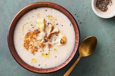 a bowl filled with oatmeal next to two spoons on a table