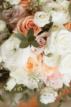 a bouquet of white and peach flowers with greenery on the stems is photographed in this close up photo