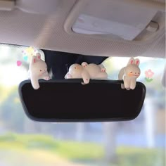 three little bunnies hanging from the side of a car