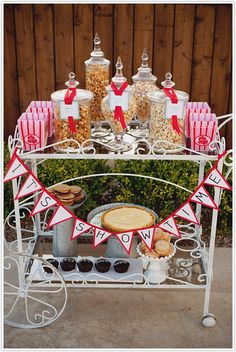 a table topped with lots of food and desserts next to a fenced in area