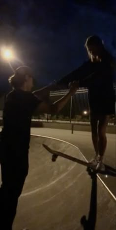 two people standing on skateboards at night