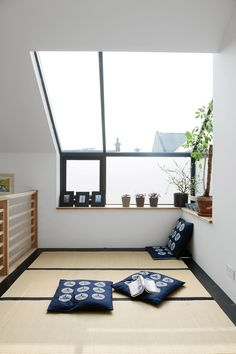 an empty room with tatami mats and potted plants in the window sill