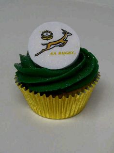 a cupcake with green frosting and a white button on top that says sa rugby