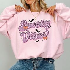 This super-soft fleece-lined Spooky Vibes Sweatshirt features a cute Halloween design - perfect for the chilly days of fall! Printed on Gildan unisex sweatshirts for the ultimate in cozy comfort. Please check the size charts for the perfect fit! Details: ✔ 50% ethically grown cotton, 50% polyester ✔ Medium-heavy weight fabric for the perfect amount of warmth ✔ Premium DTG prints - no peeling or cracking ✔ Classic fit in your regular size ✔ Easy care: Machine washable, maintains shape and color ? Fall Kawaii Style Sweatshirt With Cartoon Print, Kawaii Cartoon Print Sweatshirt For Fall, Kawaii Letter Print Tops For Fall, Pink Cartoon Print Sweatshirt For Fall, Kawaii Letter Print Sweatshirt For Fall, Fall Kawaii Sweatshirt With Graphic Print, Fall Kawaii Graphic Print Sweatshirt, Trendy Fall Sweatshirt With Character Print, Trendy Character Print Sweatshirt For Fall