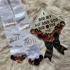 two white graduation stoles with black and gold decorations