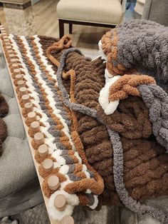 two knitted stuffed animals sitting on top of a couch