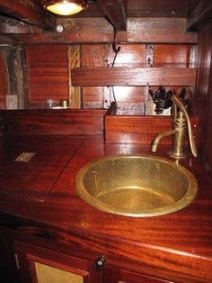 a sink in a wooden bathroom with a brass faucet