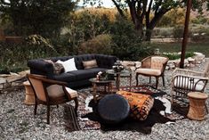 a living room filled with lots of furniture and decor on top of gravel covered ground