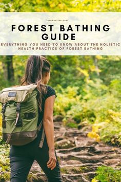 a woman hiking in the woods with text overlay reading forest bathing guide everything you need to know about the holitic health practice of forest bathing