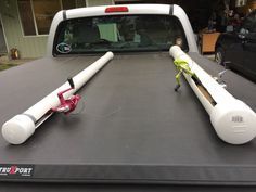 a white truck with two large fishing rods on it's flatbed