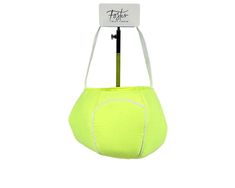 a neon yellow ball hanging from a hook on a white wall with a tag attached to it