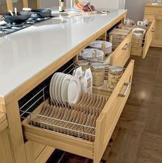 an open drawer in a kitchen filled with dishes