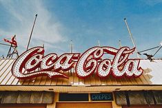 a large coca cola sign on top of a building