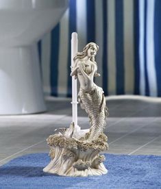 there is a statue that is on the floor in front of a toilet and rug