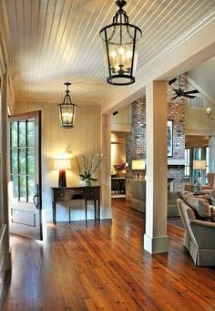 an image of a living room with wood floors and lighting fixtures on the ceiling is shown