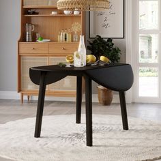 a dining room table with wine bottles and lemons on it, in front of an open bookcase