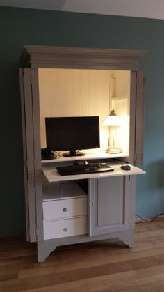 a desk with a computer on top of it in a room that is painted blue