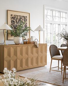 a dining room table with chairs and vases on it