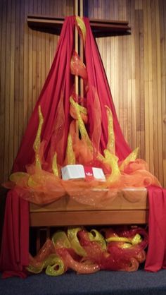 the altar is decorated with red cloths and yellow flowers in front of a crucifix