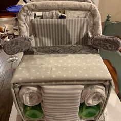 a diaper bag sitting on top of a wooden table next to a baby seat