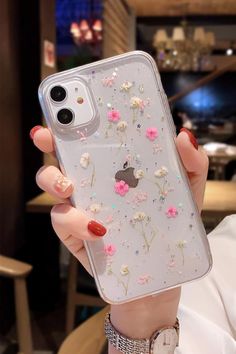 a woman holding up her phone case with flowers on the front and back cover in clear