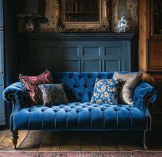 a blue couch sitting in front of a mirror