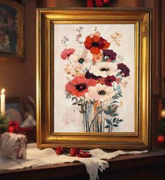 a painting with flowers in it on a table next to a candle and christmas decorations