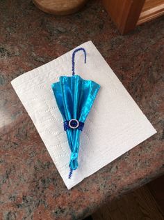 a blue umbrella sitting on top of a white napkin