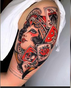 a woman's arm with tattoos on it and playing cards in the shape of her face