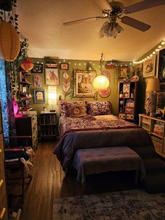 a bed room with a neatly made bed and lots of pictures on the wall above it