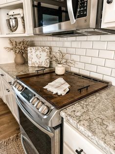 a stove top oven sitting inside of a kitchen next to a microwave above a counter