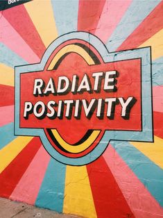 the word radiate positivity is painted on a wall with sunbursts