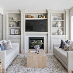 a living room filled with furniture and a flat screen tv mounted on the wall above a fire place