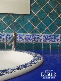 a bathroom sink with blue and white tiles on the wall