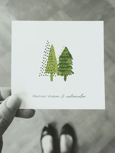 someone holding up a card with trees on it